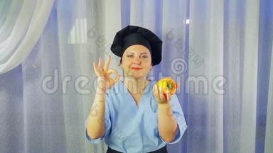 一个穿着围裙做饭的女人微笑着，手里拿着一根<strong>黄</strong>色的胡椒，用她的手表现得<strong>很</strong>好。
